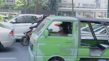 Bir yolcu aracının sürücüsü yol boyunca sürüyor ve kameraya bakıyor - 4K Yatay Video