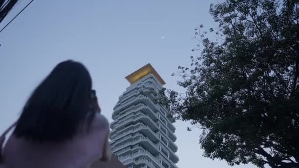 Girl Standing Street Taking Pictures Sky Building Horizontal Video — Stockvideo