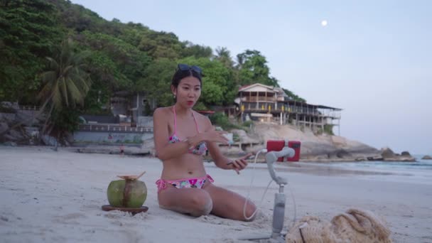 Thai Girl Blogger Bikini Broadcasting Live Stream Sitting White Sand — Vídeos de Stock