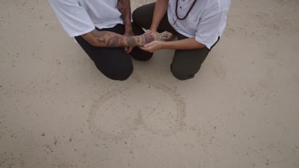 Male Gay Couple Beach Squatting Position Holding Hands Heart Shape — Stockvideo