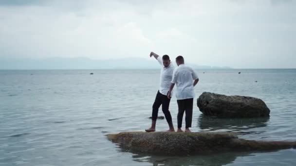 Joyful Gay Couple Has Fun Dancing Rock Shallow Water Holding — Vídeo de Stock