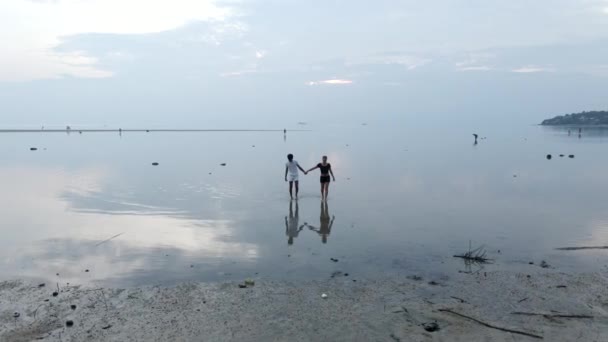 Interracial Travelers Couple Holding Hands Walking Out Shallow Sea Water — Stockvideo