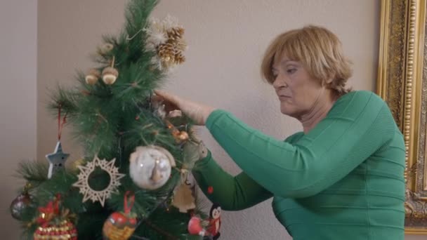 Noel Ağacının Dallarındaki Süslemeleri Tamir Eden Yaşlı Kadın Orta Boy — Stok video