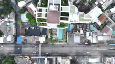 Bangkok, Tayland 'daki yüksek binaların ve yol trafiğinin yukarıdan görünüşü. Hava Aracı - 4K Yatay Görüntü