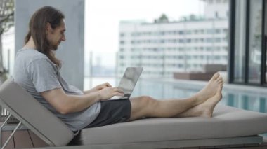 A Man Is Typing On His Laptop And Then Look And Smile At The Camera. Side View - 4K Horizontal video