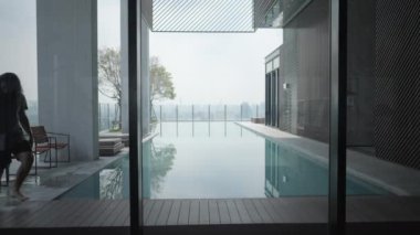 Yalnız adam havuz başında elinde bir dizüstü bilgisayarla çatıda yürüyordu. Statik Çekim - 4K Yatay Görüntü