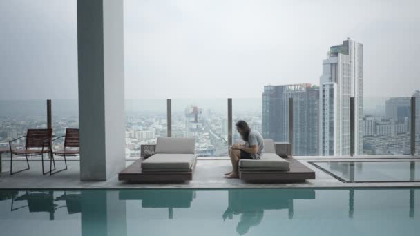 Guy Using Laptop While Sitting Lounge Poolside Building Rooftop Bangkok — Wideo stockowe
