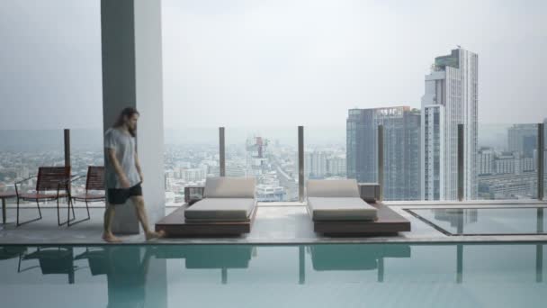 Long Haired Digital Nomad Walks Sits Pool Checks His Cellphone — Stockvideo