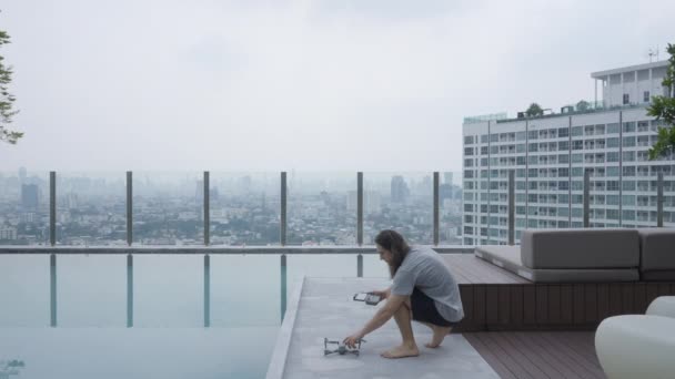 Caucasian Guy Setting His Drone Camera While Hotel Rooftop Static — Vídeos de Stock