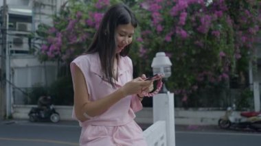 Sınır duvarında oturan akıllı telefonuyla sörf yapan bir kadının hayran olması - 4K Yatay Video