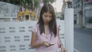 Hevesle telefonuna bakan bir kadın ve yanından geçen bir araba - 4K Yatay Video