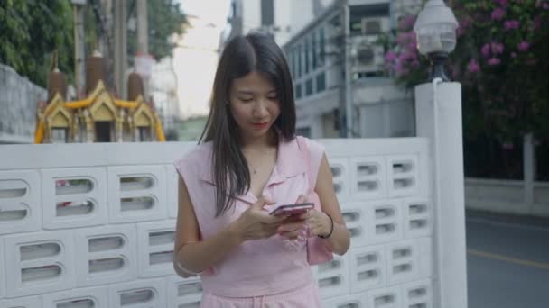 Asiatisches Mädchen Steht Lachend Auf Der Straße Und Chattet Auf — Stockvideo