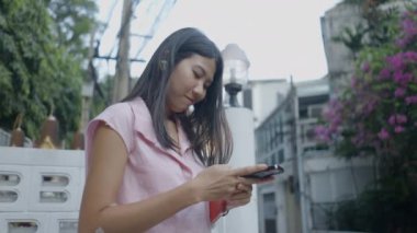 Güzel bir kız pembe bluz giyerken gülümsüyor - 4K yatay video