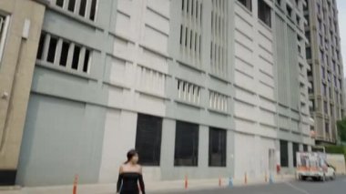 A girl is crossing the street in front of her office - 4K horizontal video