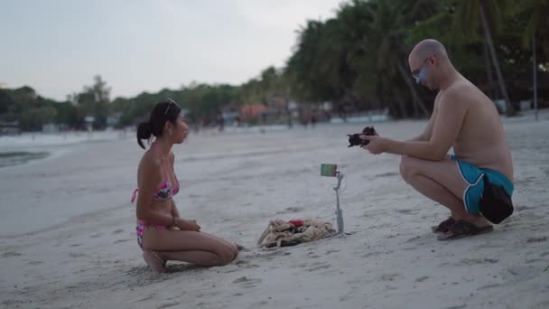 Blanke Fotograaf Man Neemt Foto Van Thais Meisje Een Bikini — Stockvideo