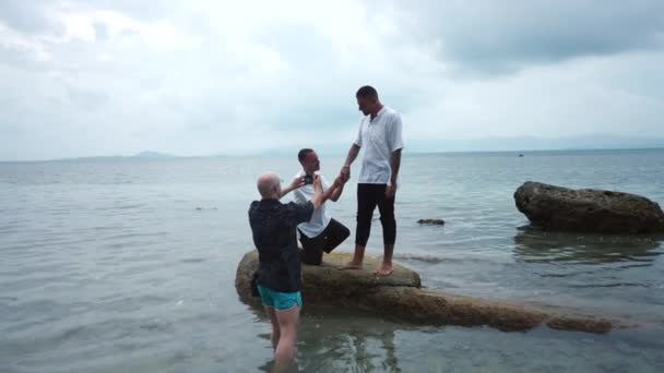 Man Photographer Takes Pictures Gay Couple Standing Rock Sea Making — Vídeos de Stock