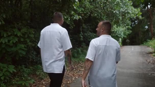 Same Sex Male Couple Talking Walk Road Tropical Island Horizontal — Vídeo de stock