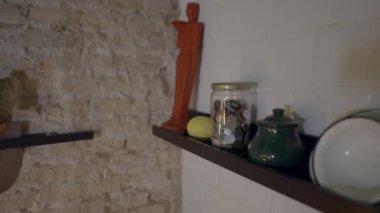 Panning push-out of plates and decorations on shelf by restaurant wall - 4K Horizontal video