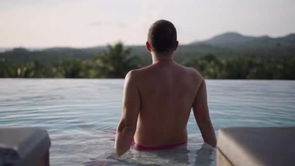Back View Undistinguished Man Enjoying Sunset Tropical Island Infinity Swimming — Stock Video