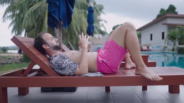 Bearded Man Traveler Watching Video Phone While Resting Wooden Deckchair — Stock Video