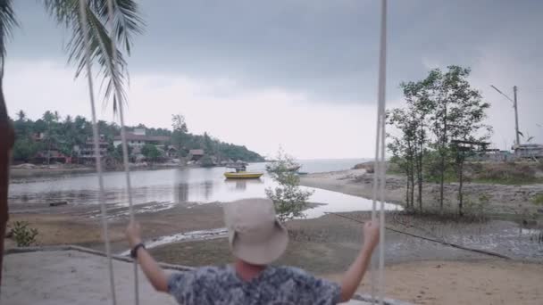 Unbekannter Mann Schwingt Auf Strandschaukel Thailändischem Dorf Zeitlupe Gimbal Push — Stockvideo