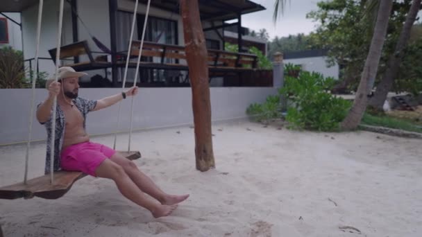 Caucasian Bearded Man Swings Beach Seafront Swing Tropical Villa Slow — Video