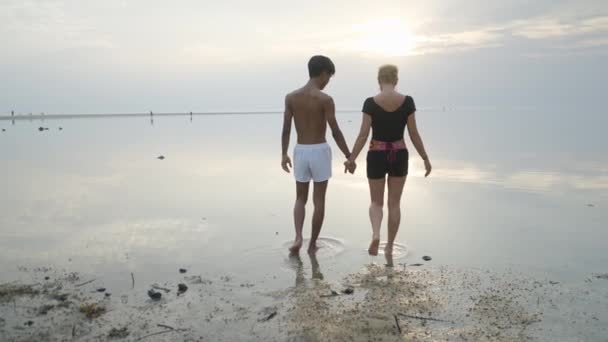 Back View Interracial Couple Walking Shallow Sea Water Sunset Slow — ストック動画