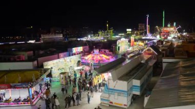 Yüz maskeli genç adam selfie videosu çekiyor ve Valencia lunaparkında boru kaydırağıyla kayarken eğleniyor. Seyahat Etkinliği - 4K Yatay Görüntü