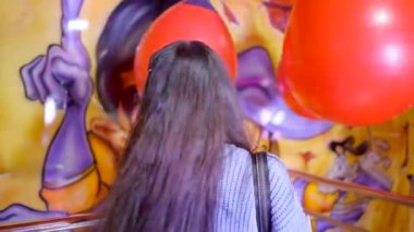  El Show de MR.Bean 4 attraction, Valencia funfair - funny teenage girl kicking rotating balloons with hands - 4K Horizontal video