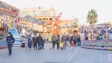 Valencia Funfair - covid-19 kısıtlamaları sırasında maskesi açık alanda yürüyen çocuklu aile - 4K Yatay video
