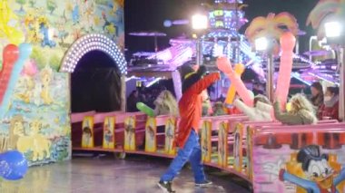 Valencia Funfair - Mickey Mouse kostümlü adam şişirilmiş balonlarla kavga ediyor ve TrenChu Chu 'da trene binen çocukları eğlendiriyor - 4K Yatay Video