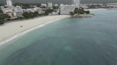 Kitesurfing At Palmanova Beach With Beachfront Hotels In Mallorca, Balearic Islands, Spain. - aerial - Horizontal
