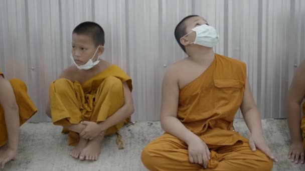 Group Young Teenage Monks Sitting Concrete Fence Wearing Face Masks — Stockvideo
