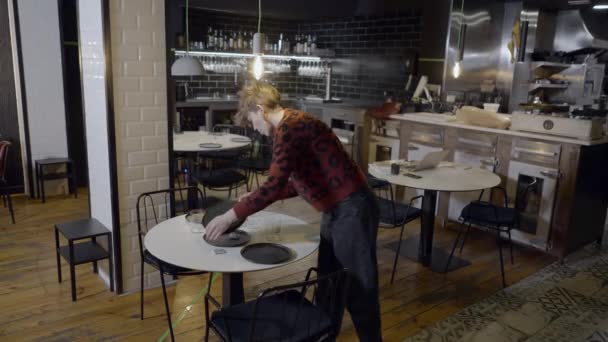 Slomo Young Woman Moving Plates Restaurant Table Horizontal Video — Stockvideo