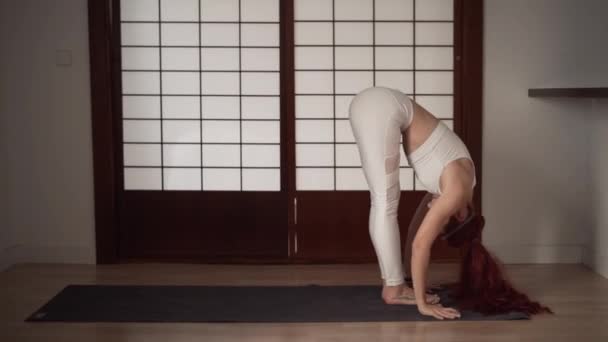Woman White Sportswear Doing Yoga Stretch Indoors Horizontal Video — стоковое видео