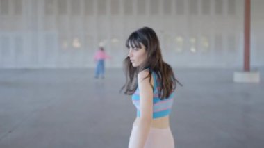 Genç kadınlar boş bir depoda paten kayıyor, el kamerasıyla çekilmiş - 4K yatay video.