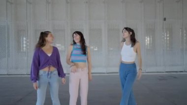 Panning shot of three girls on roller skates chatting and laughing - 4K Horizontal video
