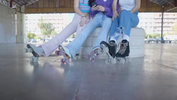 Three Girls Rollerskates Sit Look Phone Laugh Tilt Horizontal Video — Video