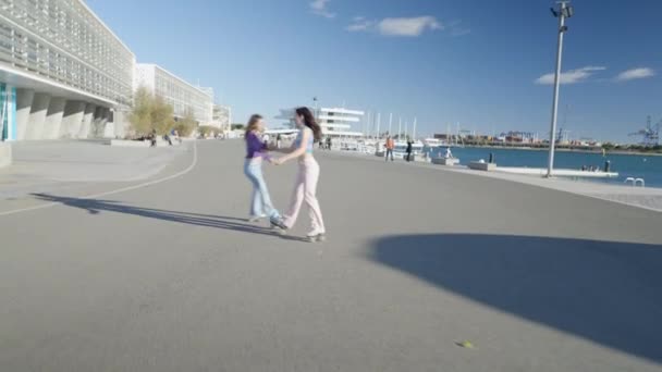 Two Girls Hold Hands Spin Roller Skates Sunlight Horizontal Video — Stok video