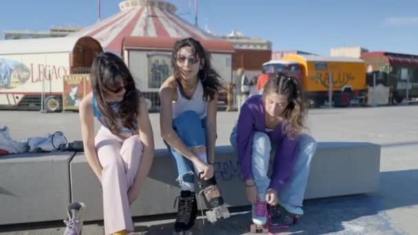 Three Girls Sit Circus Outdoors Tie Roller Skates Slomo Horizontal — Vídeo de stock