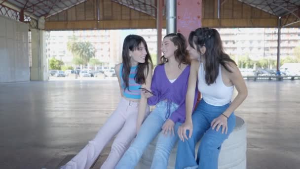Three Dark Haired Girls Sit Laugh While Using Phone Slomo — ストック動画
