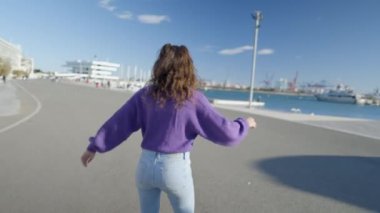 Close view of young woman spinning around on roller skates, slomo - 4K Horizontal video