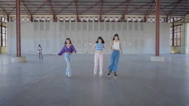 Drie Meisjes Kleurrijke Kleding Rolschaatsen Naar Langs Camera Horizontale Video — Stockvideo