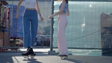 Slomo of legs of girls moving around on rollerskates outdoors, no face - 4K Horizontal video