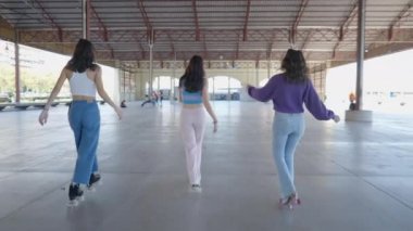 Slomo pan üç siyah saçlı kızın paten kayması - 4K Yatay Video