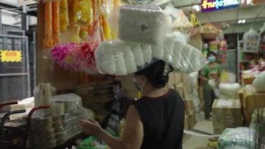 Female Vendor Carries Packs Of Fresh White Flowers On Her Head At The Stall In Pak Khlong Talat, Bangkok, Thailand. medium shot - 4K Horizontal video