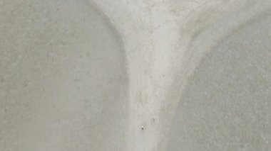 Tayland 'da, Koh Phangan' da güneş doğarken istiridye toplayan insanların olduğu düşük dalgalı kumsallar. Hava Aracı Eğimi - 4K Yatay Görüntü