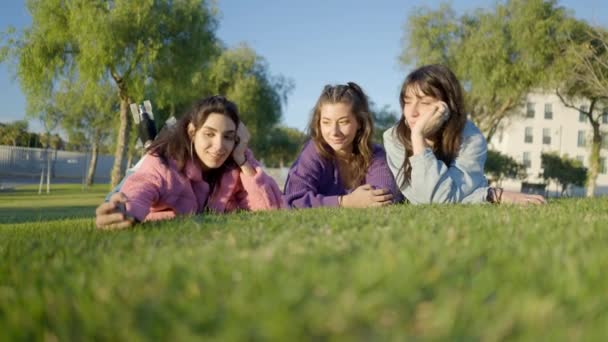 Three Girls Lie Grass Take Selfie Phone Ground View Horizontal — Αρχείο Βίντεο