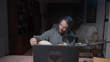 Bearded musician doing a selfie before playing a song online in a streaming - Slow motion shot