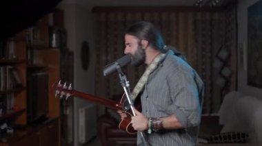 Manly bearded man finishing an online concert at home - Middle shot
